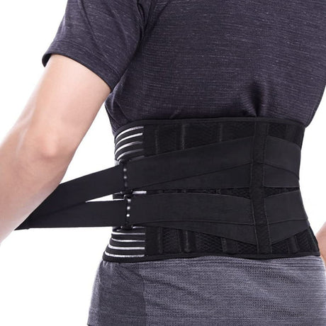 Person wearing a black back support belt on a white background