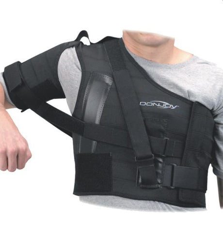 Person wearing a black DonJoy shoulder brace on a white background