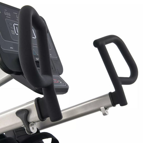 Close-up of a recumbent stepper machine with digital display and handlebars on a white background