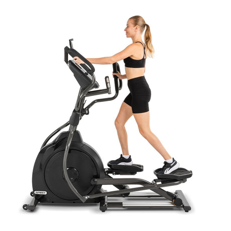 Woman exercising on aelliptical machine against a white background