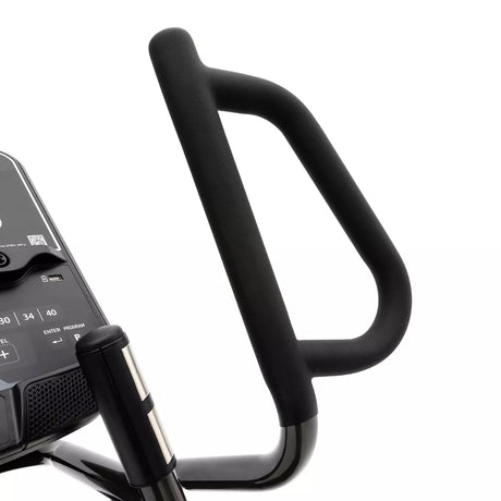 Close-up of a black exercise bike handlebar with a digital display on a white background